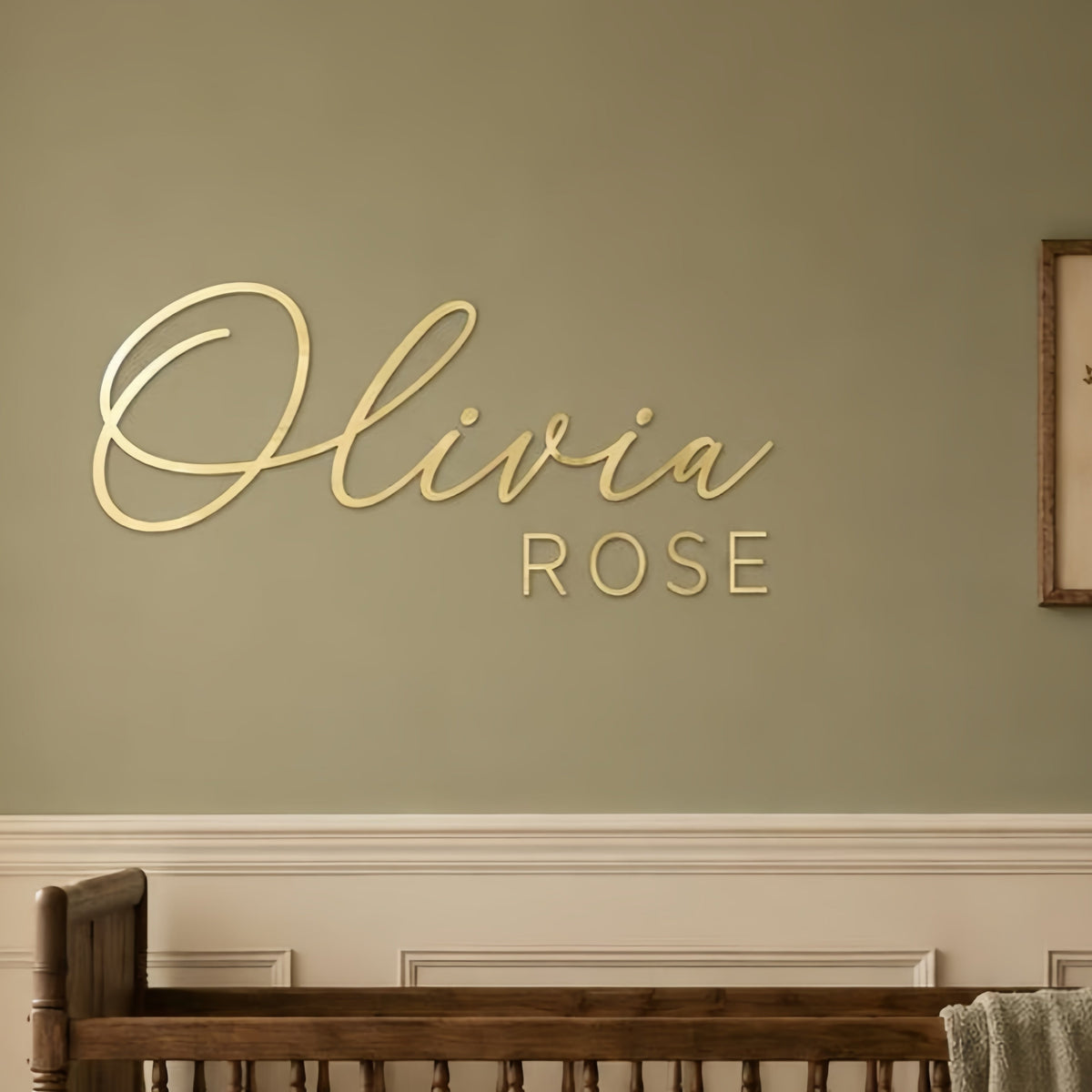 Custom acrylic nursery name sign in gold script mounted above a white crib