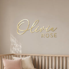 Custom acrylic name sign mounted above a crib in a modern nursery room