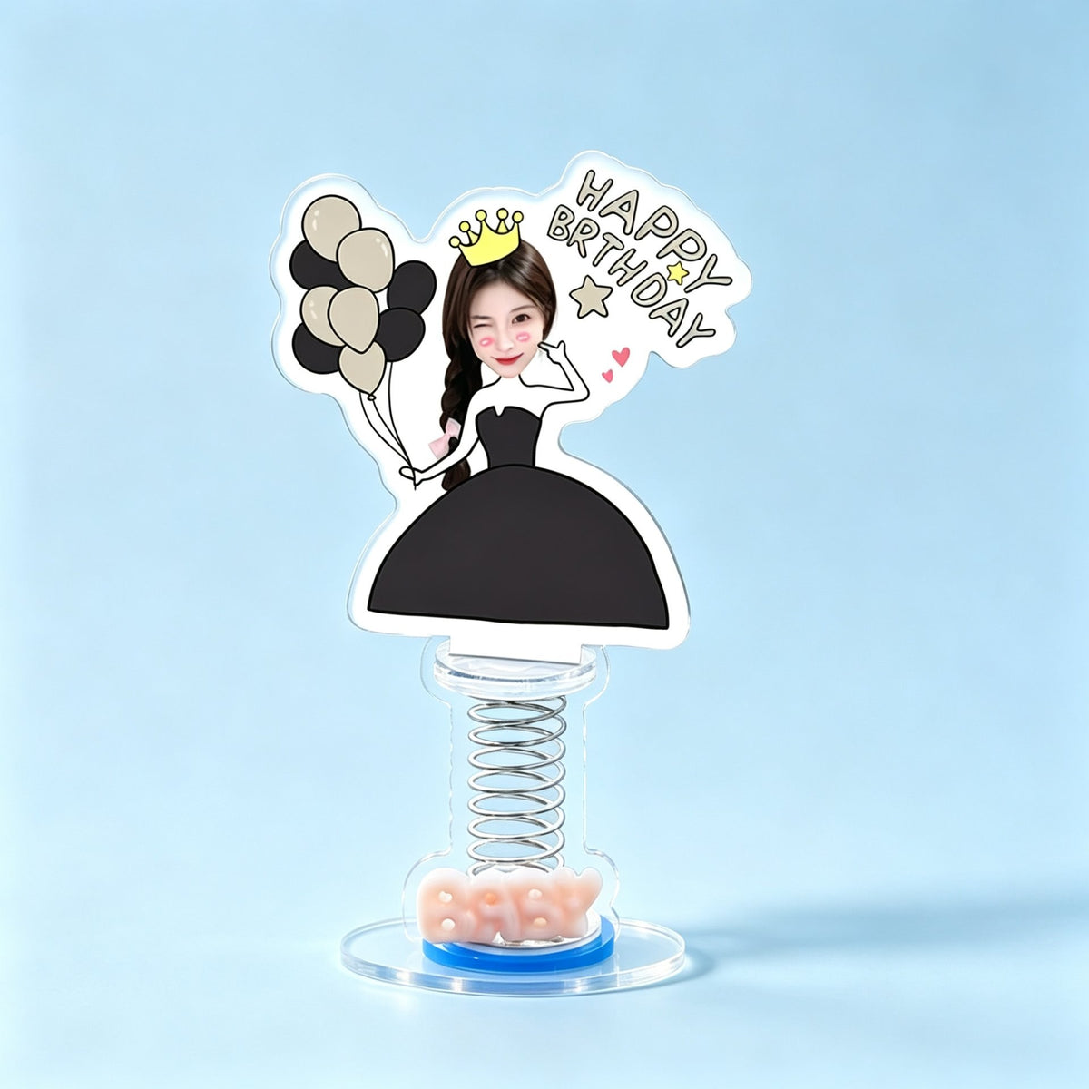 Custom birthday queen photo spring bobblehead — woman in a black gown and golden crown winking with black and gold balloons and a Happy Birthday sign, acrylic figure bouncing on a spring base