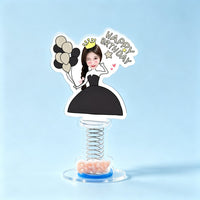Custom birthday queen photo spring bobblehead — woman in a black gown and golden crown winking with black and gold balloons and a Happy Birthday sign, acrylic figure bouncing on a spring base