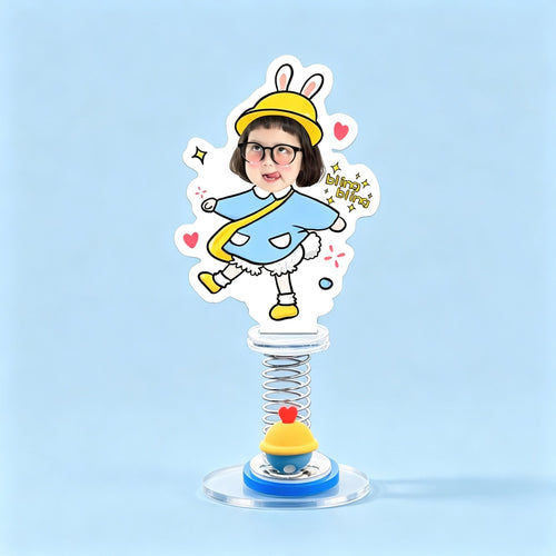 Custom bunny hat kid photo spring bobblehead — cheeky kid in a yellow bunny hat and blue poncho strutting with bling bling stars, acrylic figure bouncing on a spring base