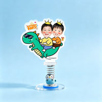 Custom dinosaur party duo photo spring bobblehead — two boys with golden crowns riding a cool green dinosaur with a Birthday Party sign, acrylic figure bouncing on a spring base