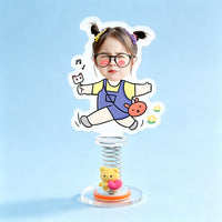 Custom jumping toddler photo spring bobblehead — funny toddler with glasses mid-jump in denim overalls with a bunny bag and music notes, acrylic figure bouncing on a spring base