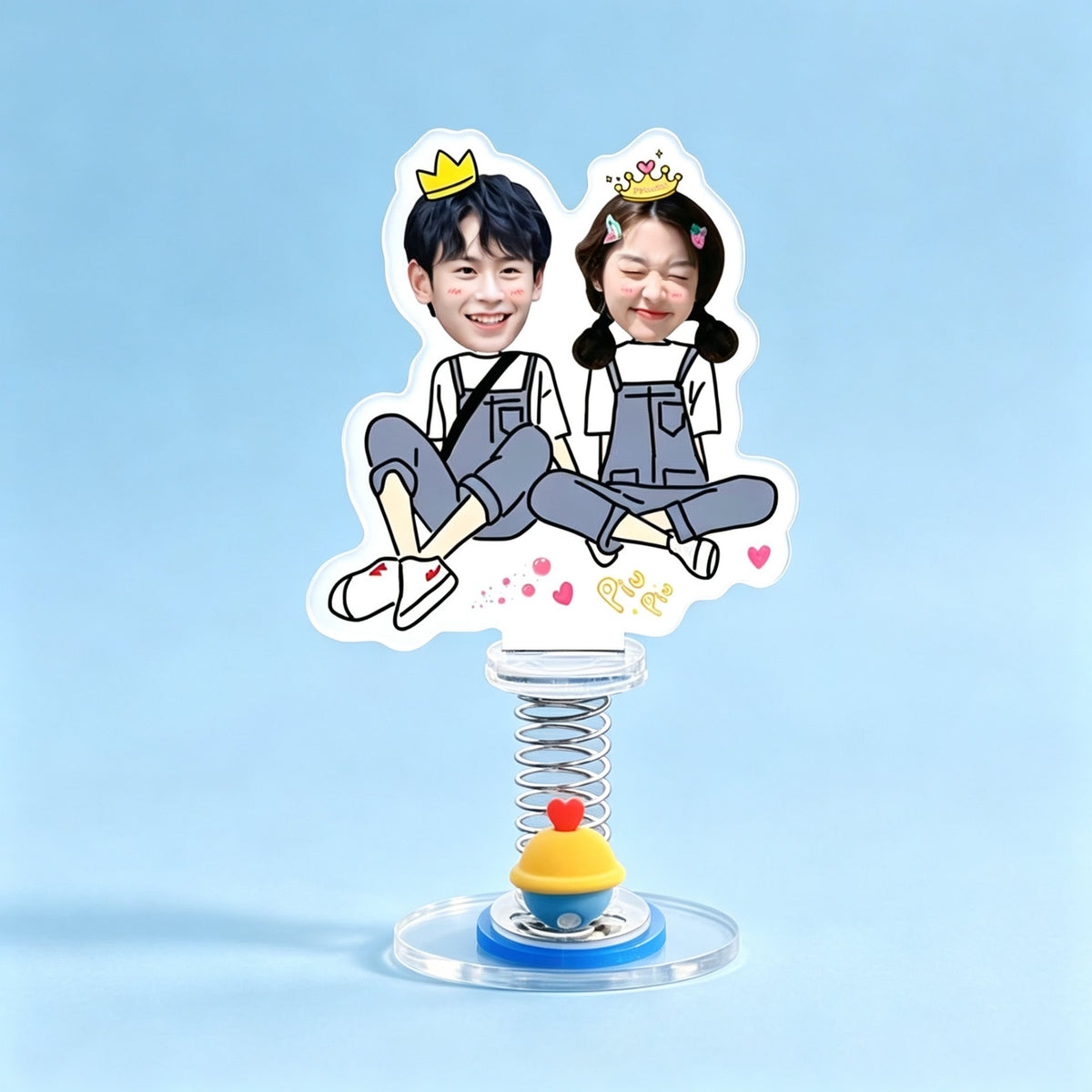 Custom sitting duo photo spring bobblehead — boy and girl with golden crowns sitting back to back in denim overalls with hearts, acrylic figure bouncing on a spring base