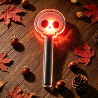 Halloween sensor light detail — glowing skull-shaped LED lamp on an acrylic stand, close-up of the motion-activated light glowing in the dark
