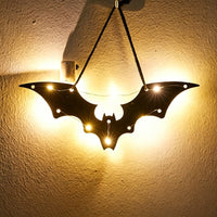 Halloween bat acrylic wall art light — wide winged bat silhouette glowing with warm LED fairy lights on a wall