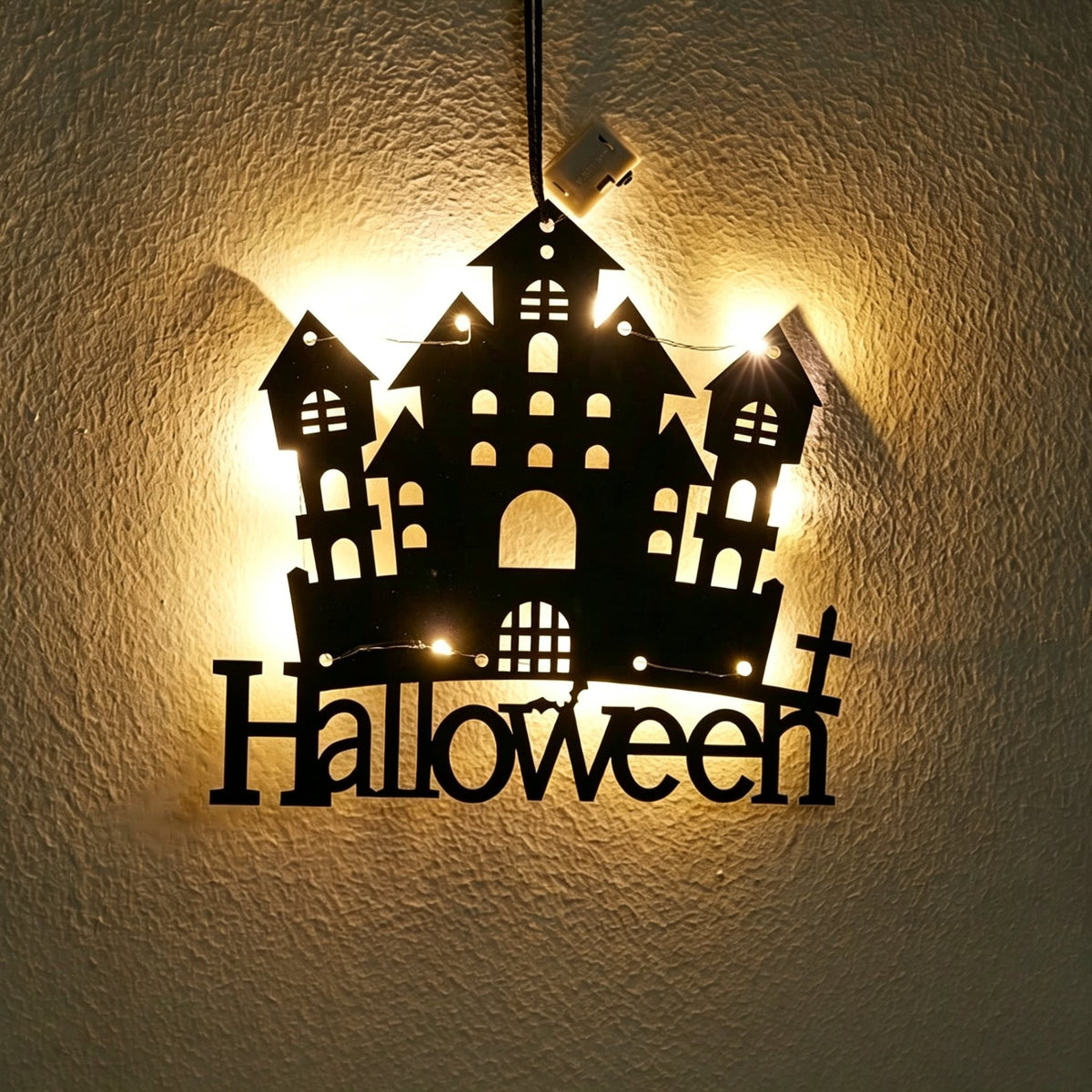 Halloween castle acrylic wall art light — haunted castle silhouette with a Halloween lettering sign glowing with warm LED fairy lights on a wall