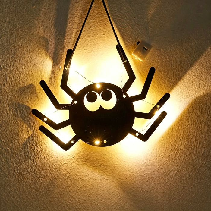 Halloween spider acrylic wall art light — big black spider silhouette with googly eyes glowing with warm LED fairy lights