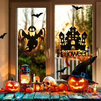 Halloween acrylic window decorations — ghost and haunted castle silhouettes with warm LED fairy lights hanging in a window with pumpkins and candles
