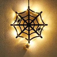 Halloween spider web acrylic wall art light — black cobweb with two crawling spiders glowing with warm LED fairy lights